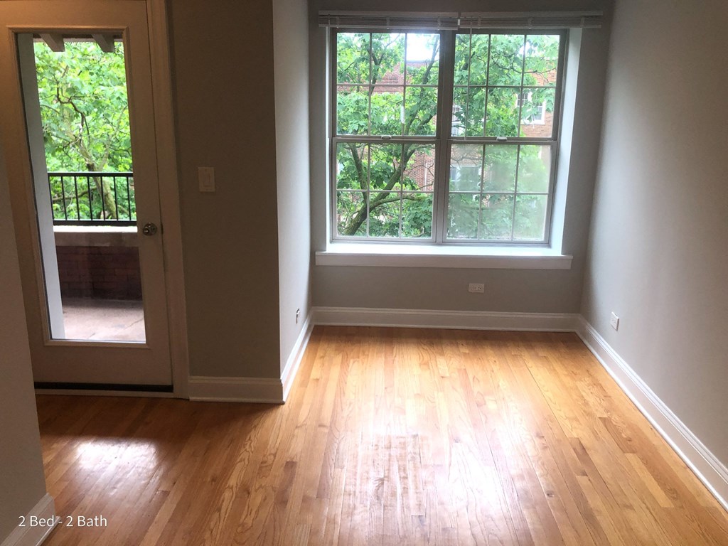 an empty room with a window and wooden floors