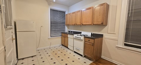 A kitchen with white appliances and wooden cabinets.