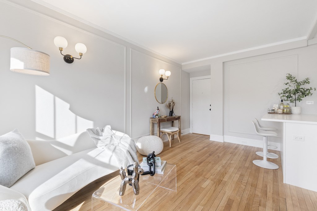 a living room with a white couch and a wooden floor