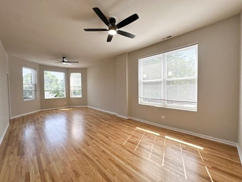 A room with wooden flooring and a ceiling fan.