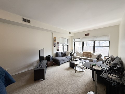 A living room with a grey couch, a black coffee table, and a flat screen TV.