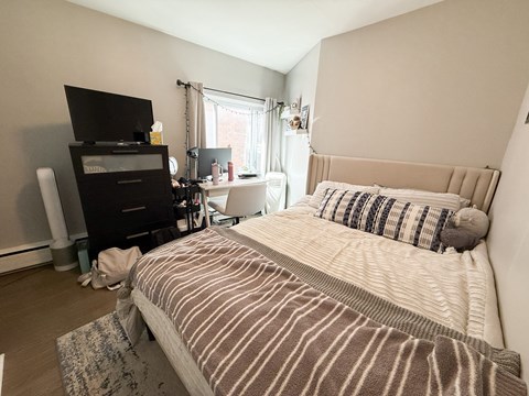 A bedroom with a large bed and a television.