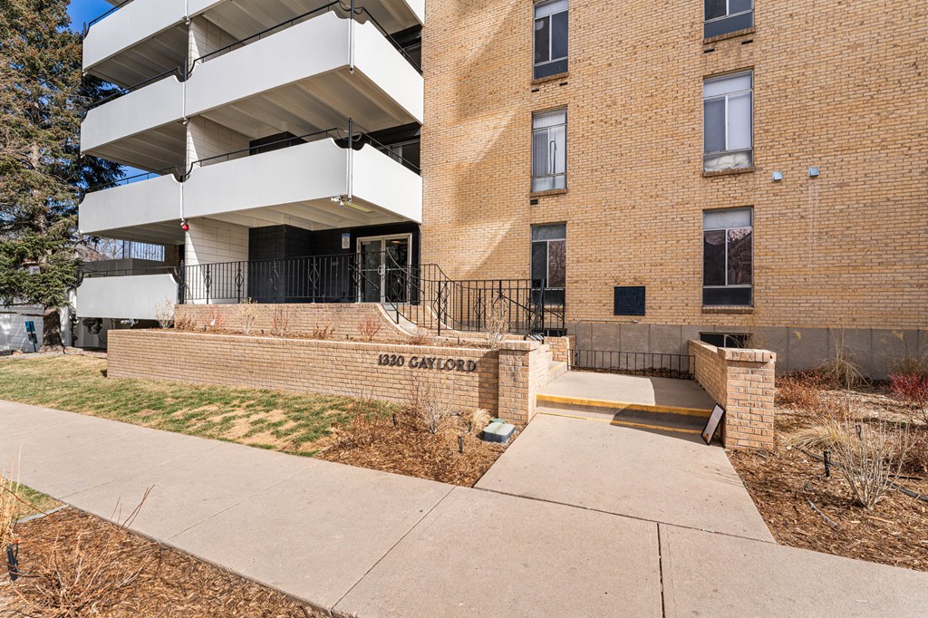 a brick building with stairs and a sidewalk in front of it