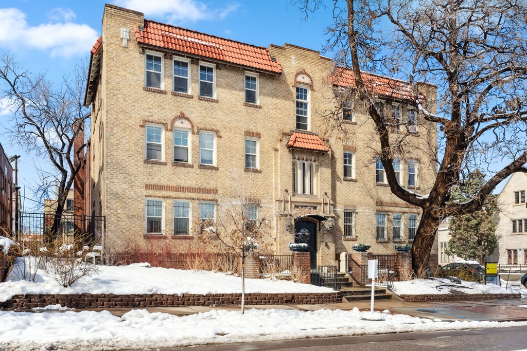 an old brick building with snow in front of it