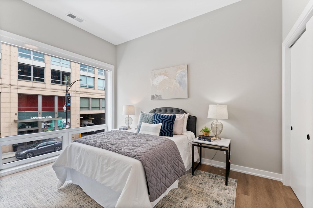 a bedroom with a large window and a bed