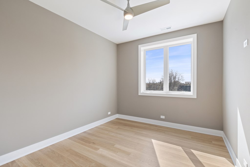 an empty room with wooden floors and a window