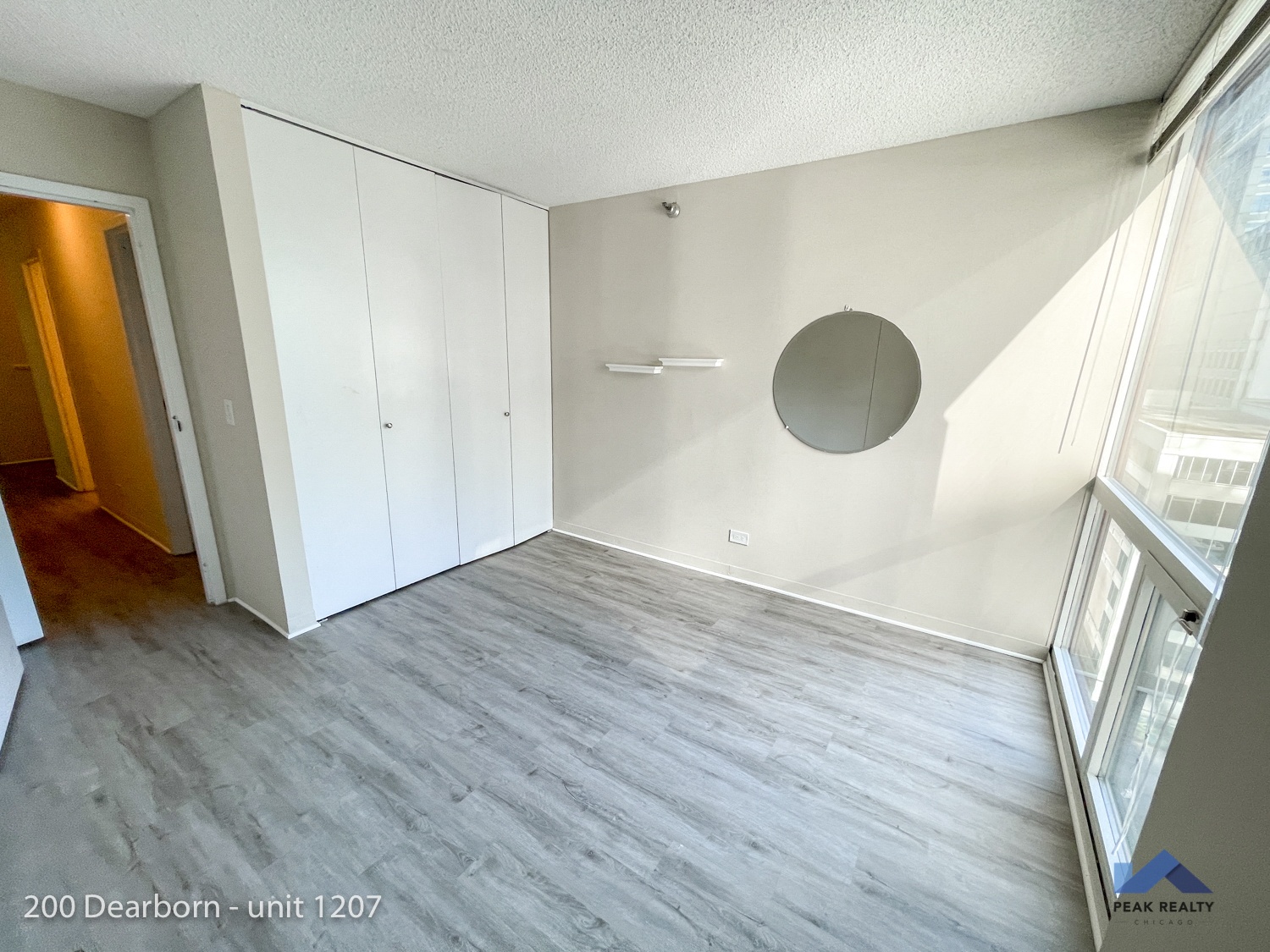 an empty living room with white cabinets and a wood floor