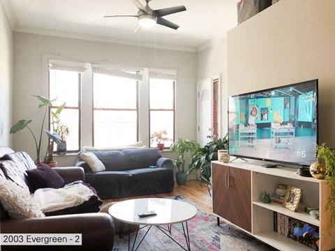 A living room with a television on a stand and a couch.