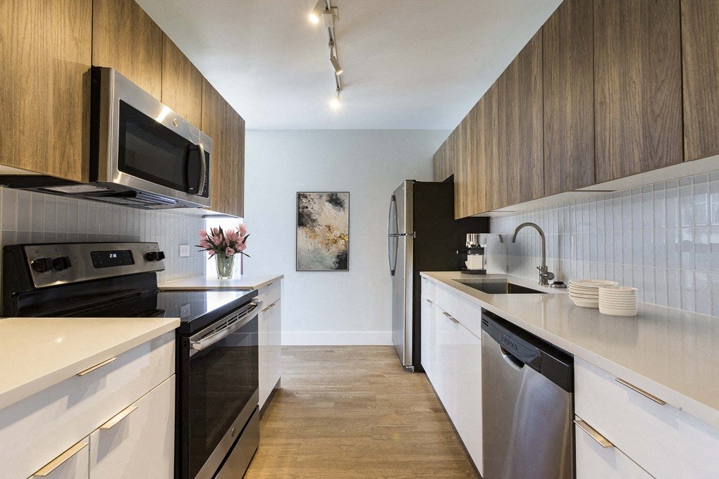 a modern kitchen with stainless steel appliances and wooden cabinets