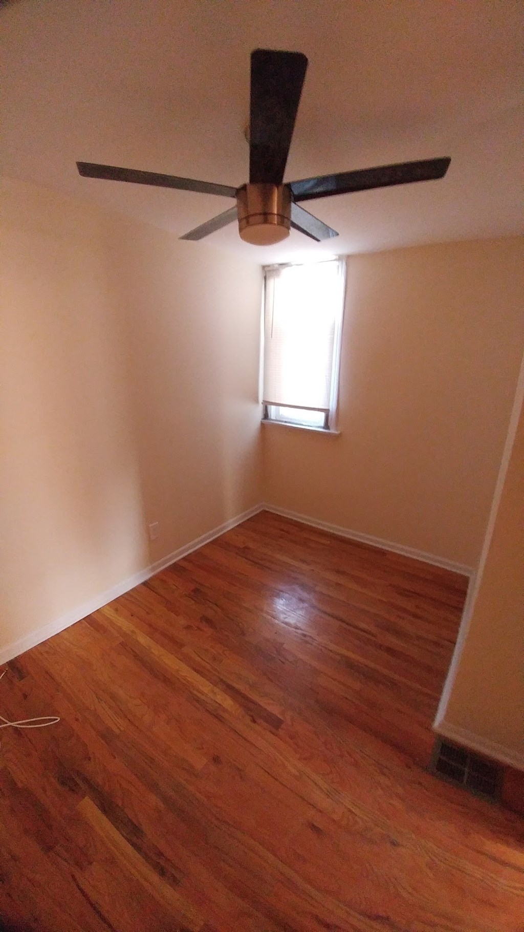 a empty room with a ceiling fan and a window