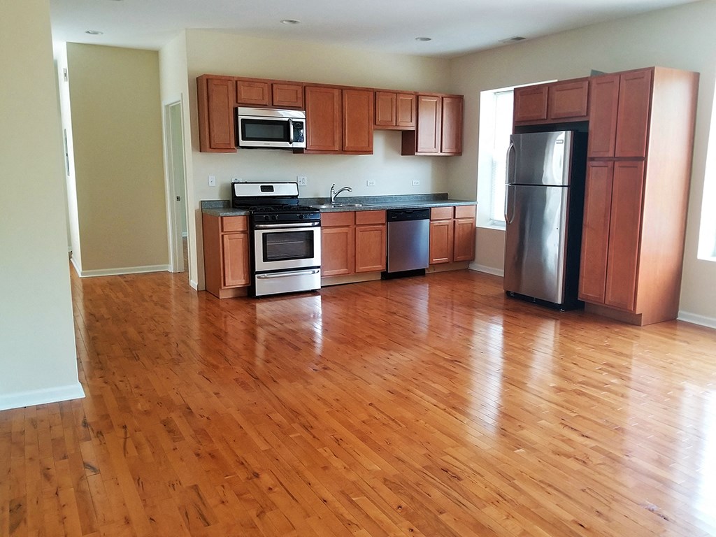 an empty kitchen with wooden floors and wooden cabinets