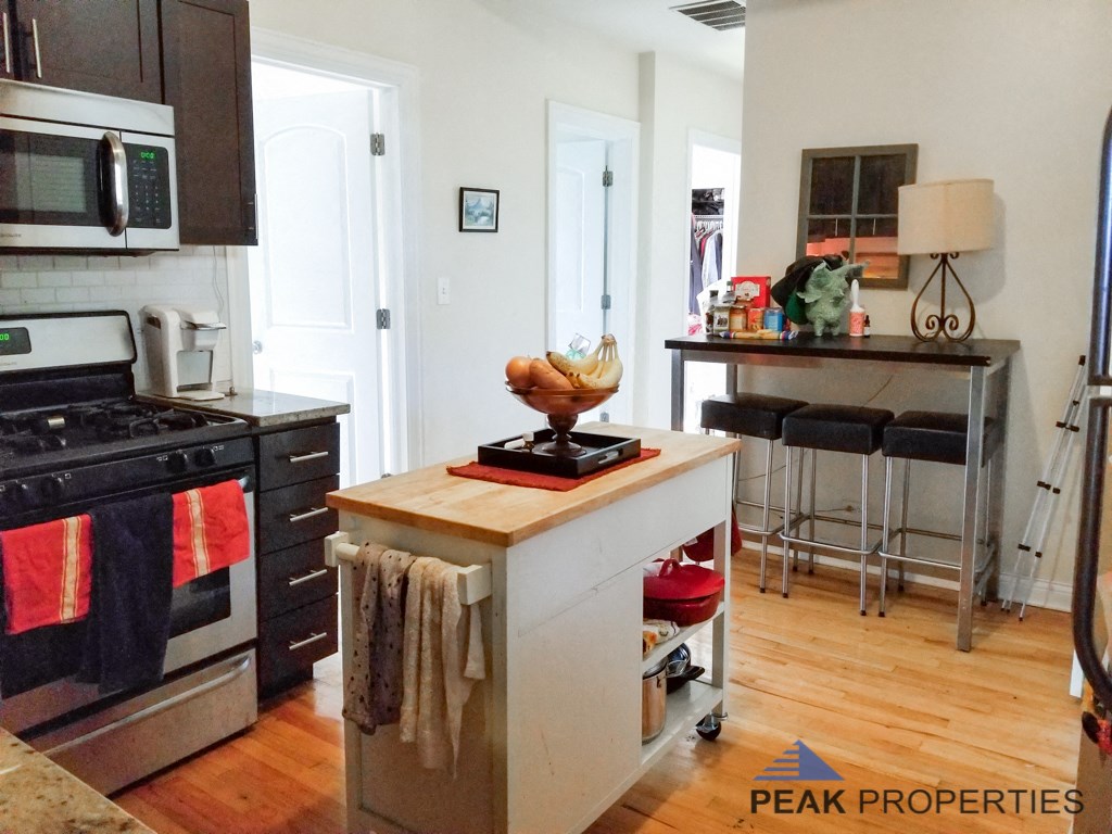 a kitchen with a island and a stove and a bar with stools