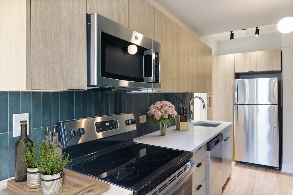 a kitchen with wood cabinets and stainless steel appliances