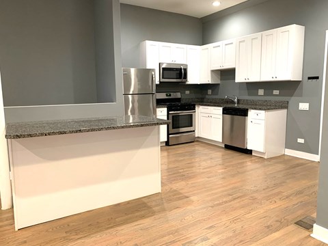 A kitchen with white cabinets and a granite countertop.