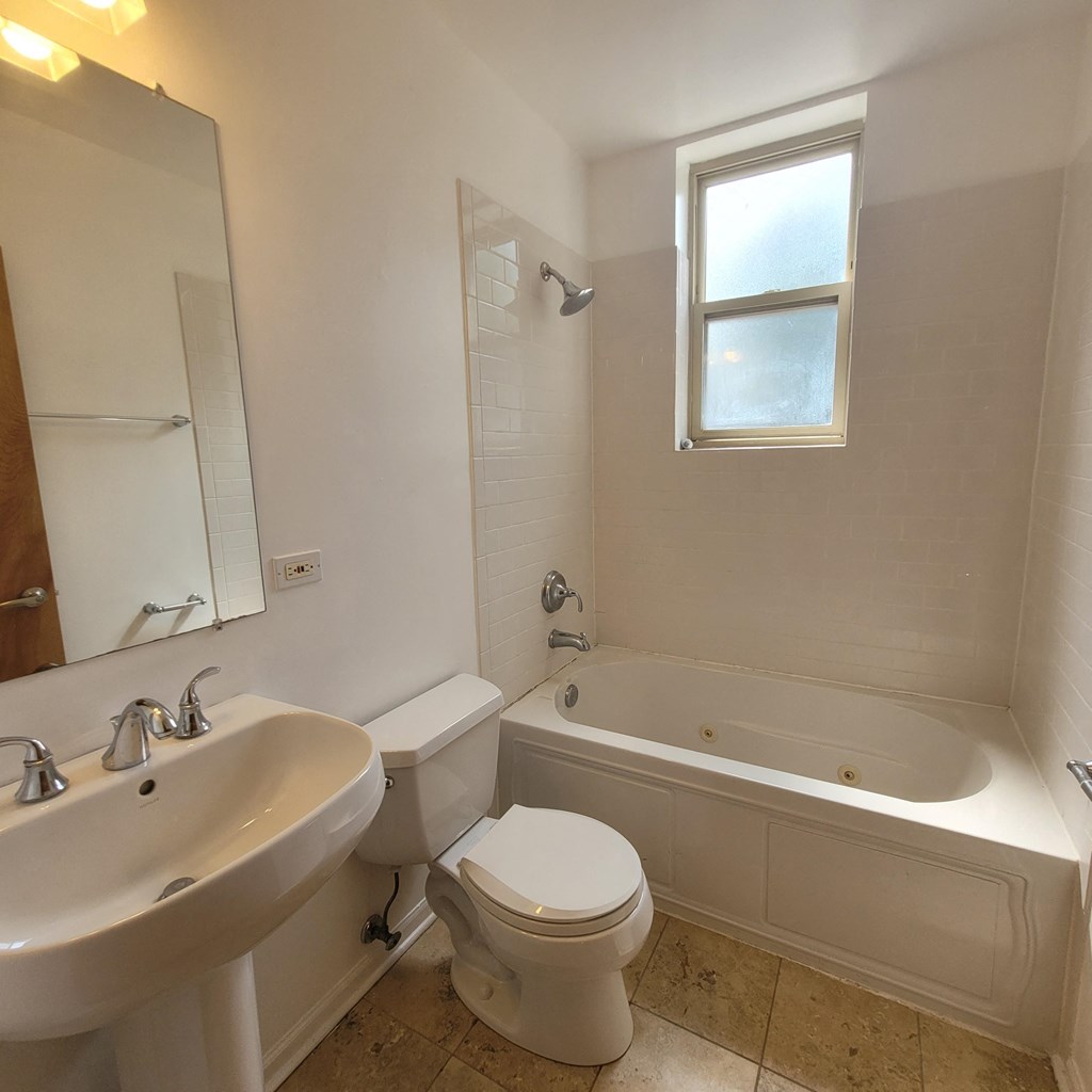 a bathroom with a toilet and a tub and a sink