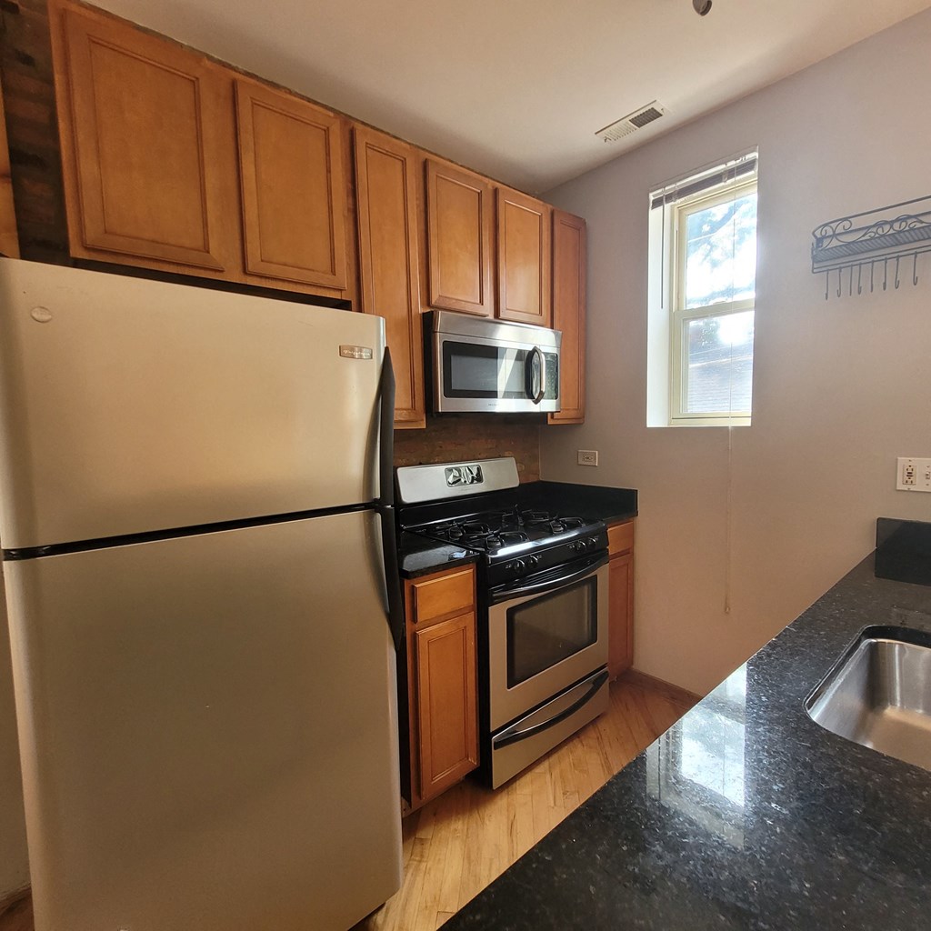 a kitchen with stainless steel appliances and wooden cabinets