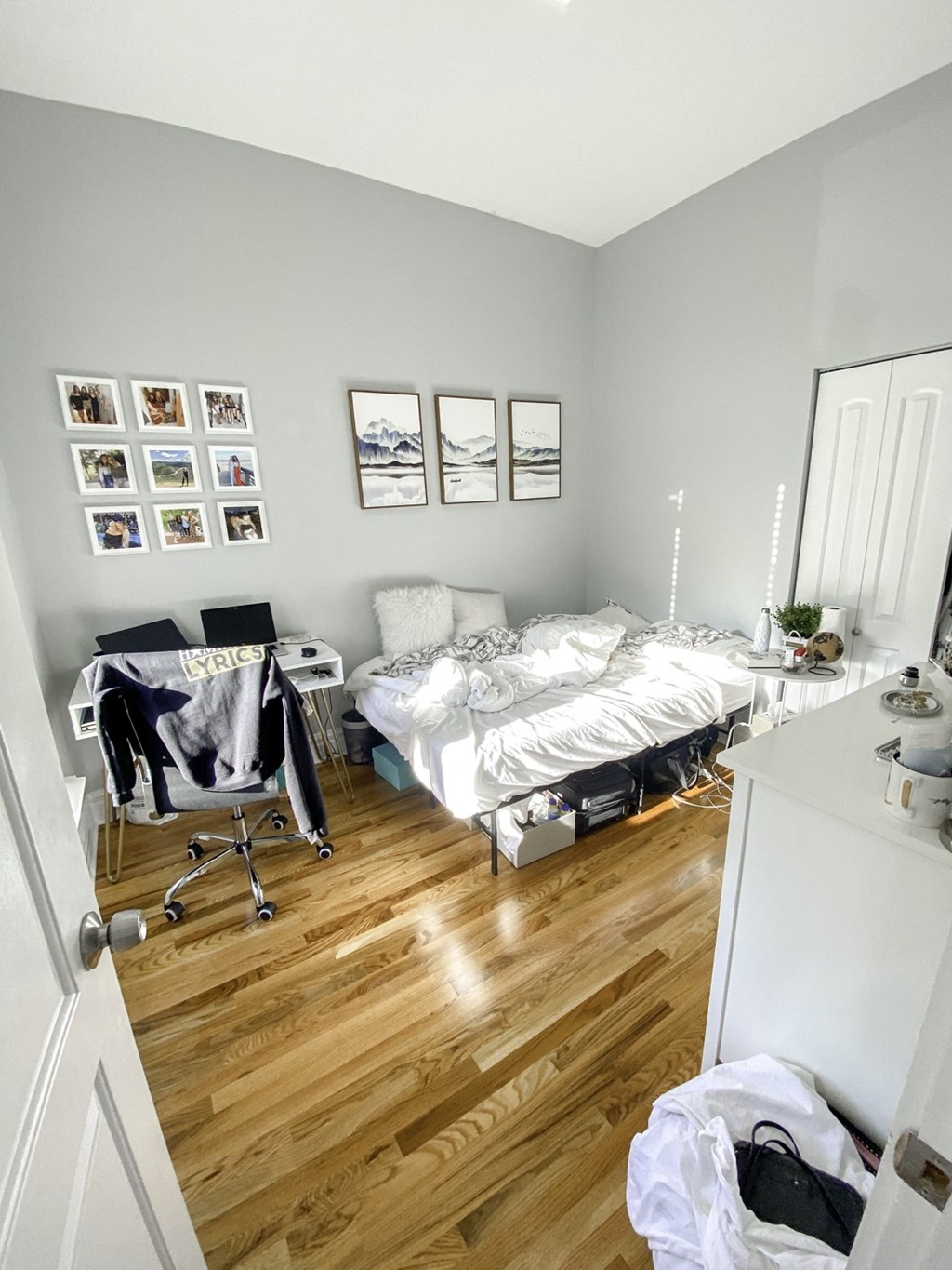 a bedroom with two unmade beds and a desk and a window