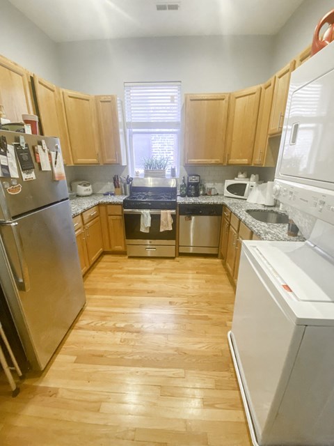 a kitchen with wooden floors and wooden cabinets