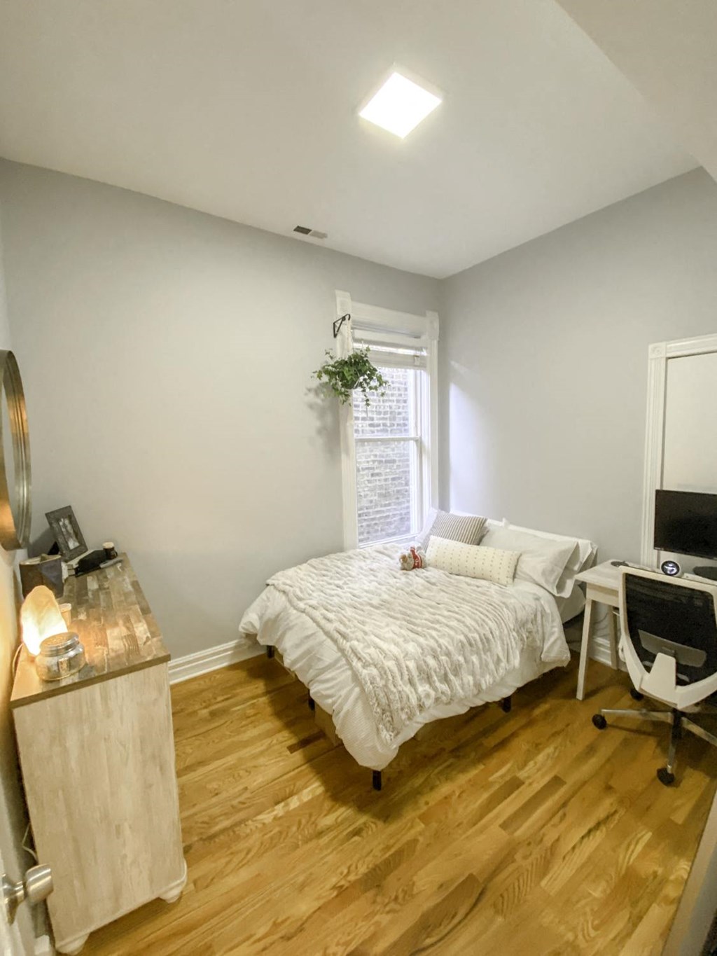 a bedroom with a bed and a desk and a window