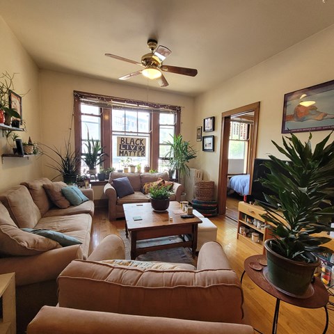 a living room filled with furniture and a ceiling fan