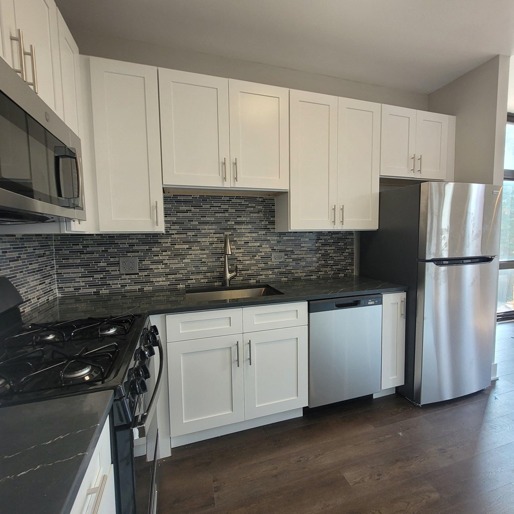 a kitchen with white cabinets and stainless steel appliances