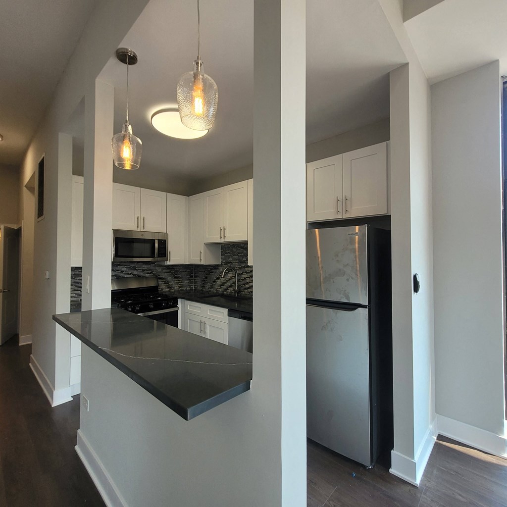 a kitchen with white cabinets and a stainless steel refrigerator