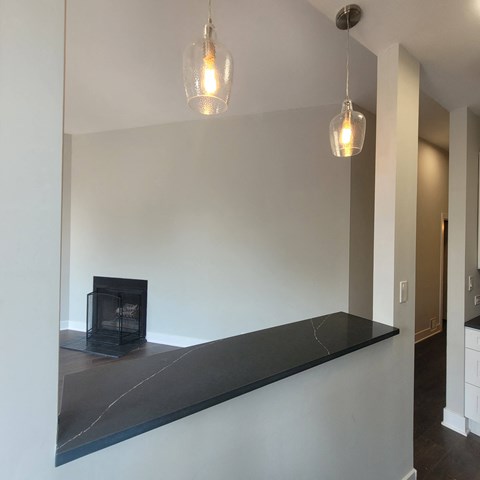 a living room with a fireplace and a long counter
