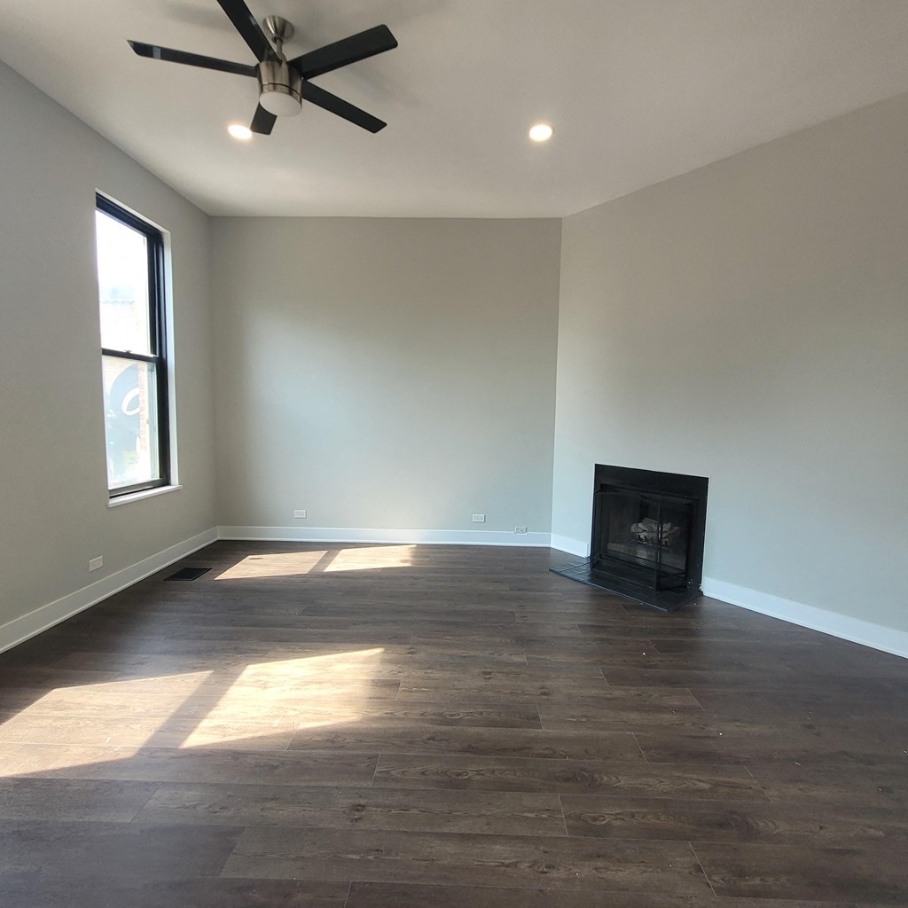 a living room with a fireplace and a ceiling fan