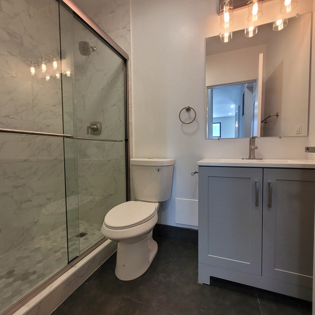 a bathroom with a toilet and a sink and a shower