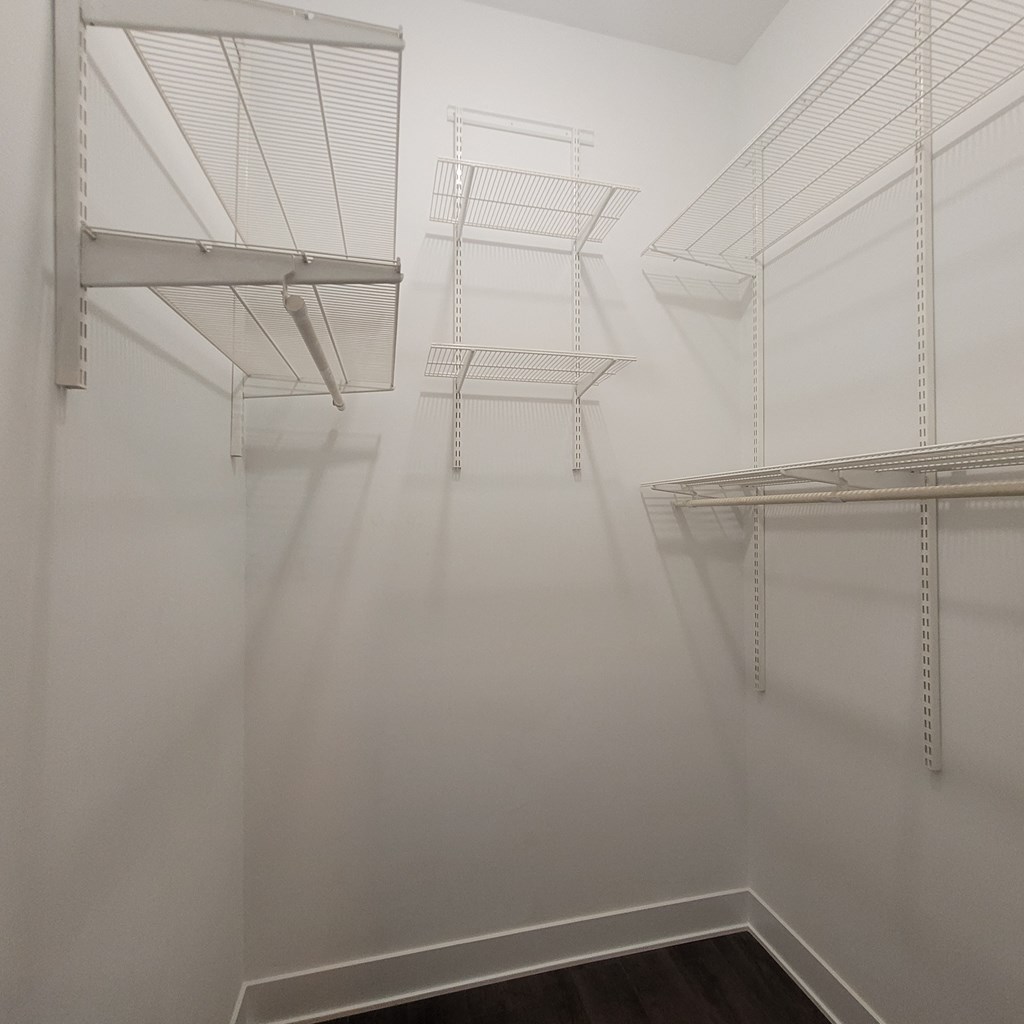 a room with white walls and a closet with shelves on it