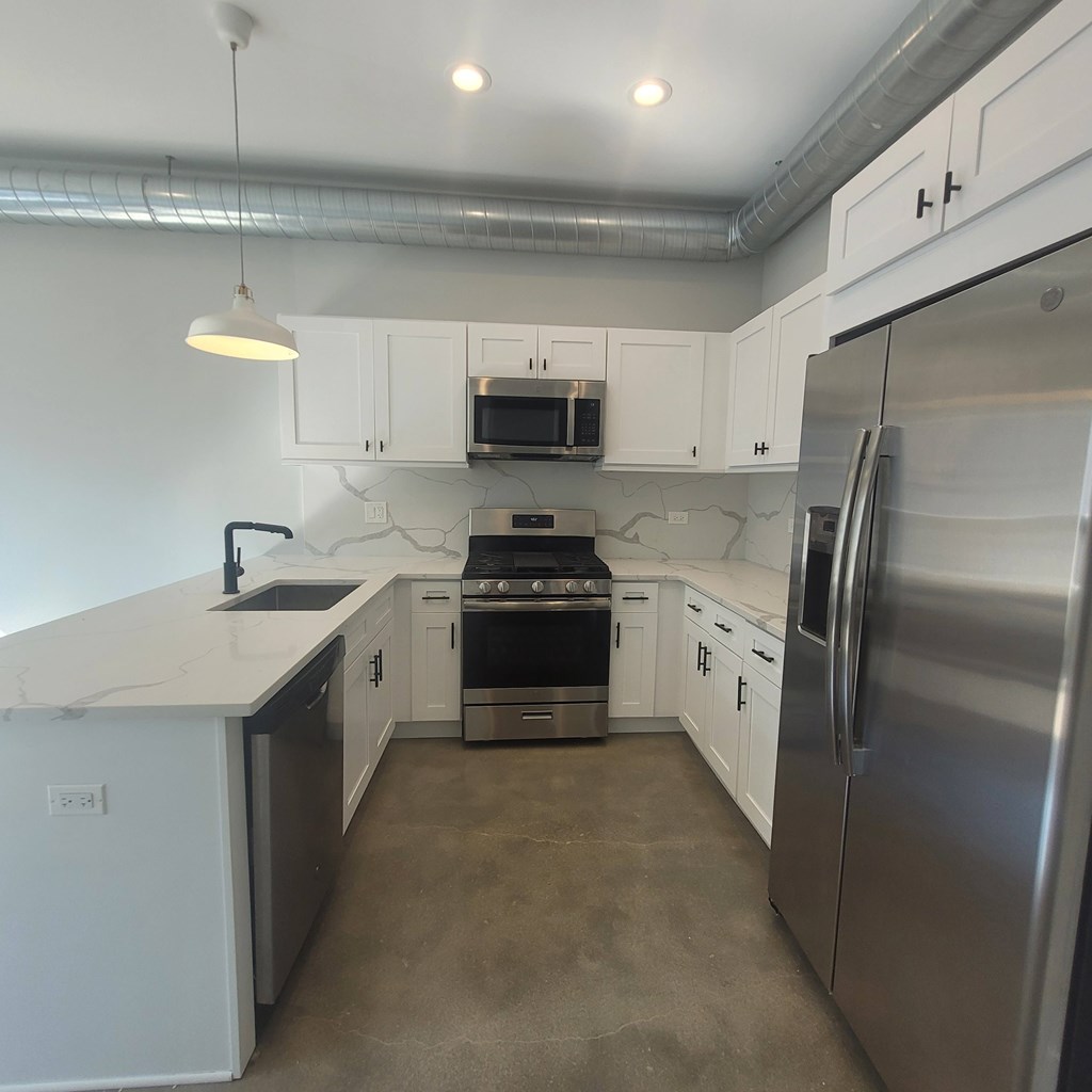 A kitchen with white cabinets and stainless steel appliances.