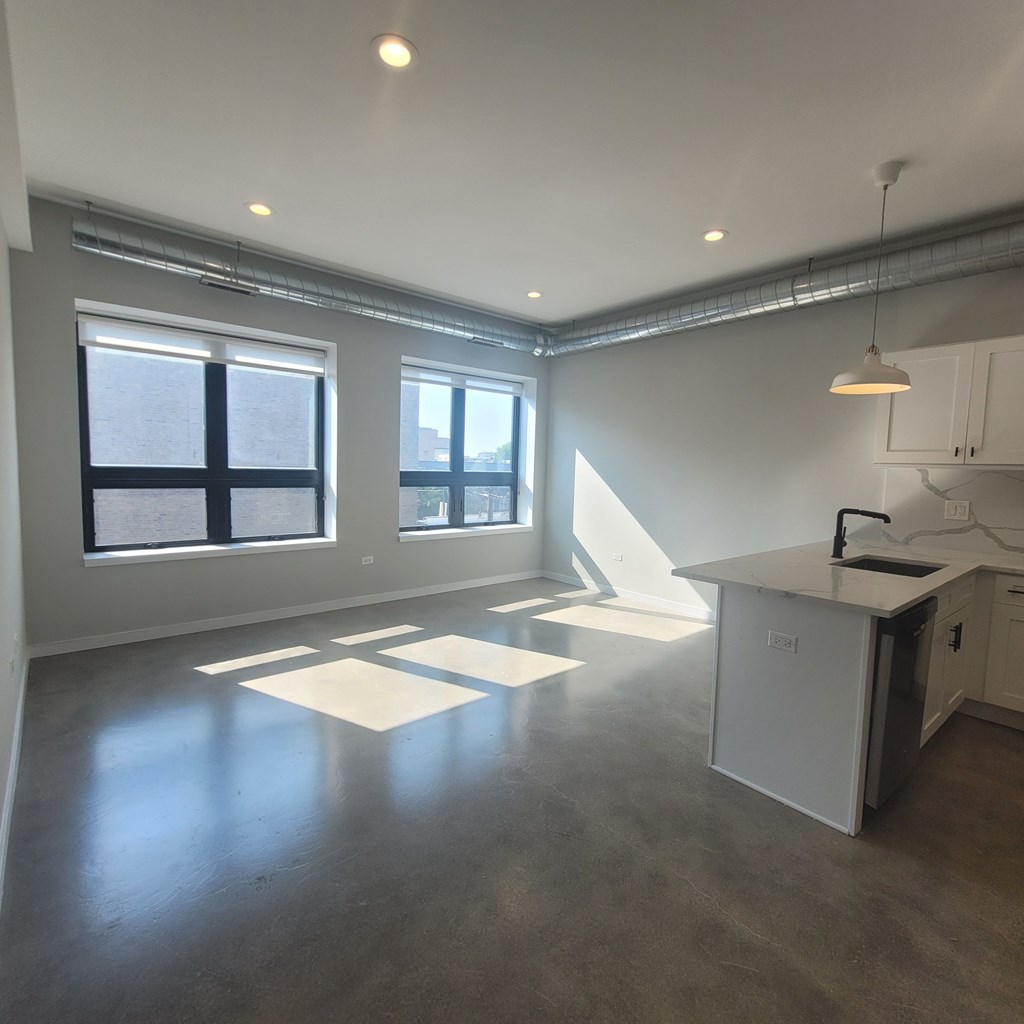 A spacious kitchen and living room with a large window and a kitchen island.