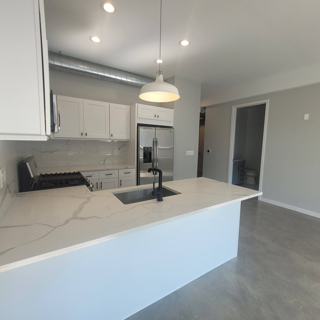 A kitchen with white cabinets and a large island.