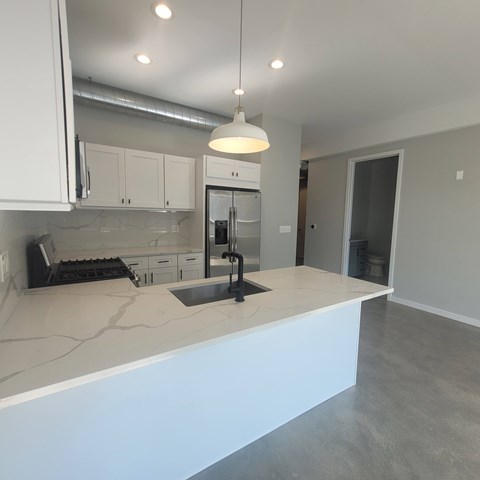 A kitchen with white cabinets and a large island.