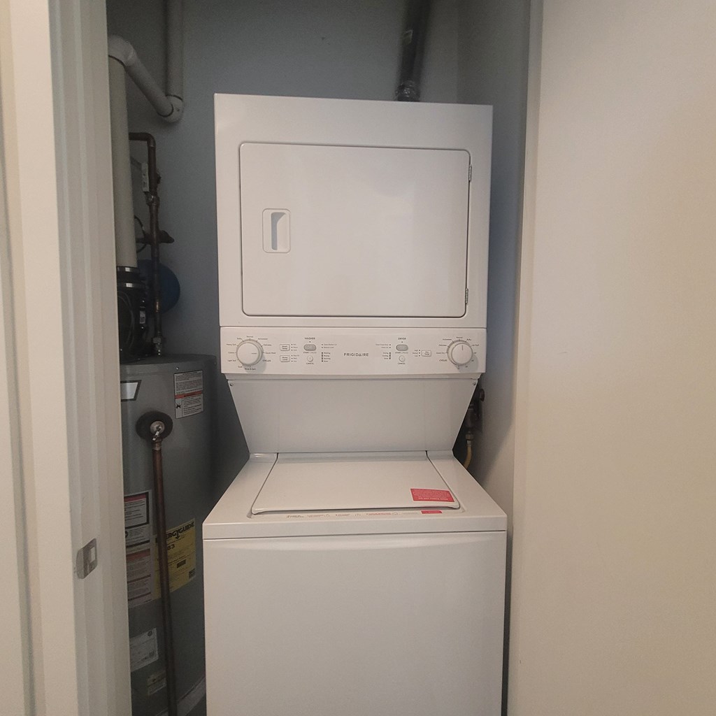 A white dryer is sitting in a laundry room.