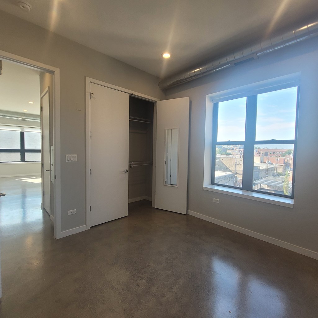 A room with a large window, a door, and a wall-mounted light fixture.