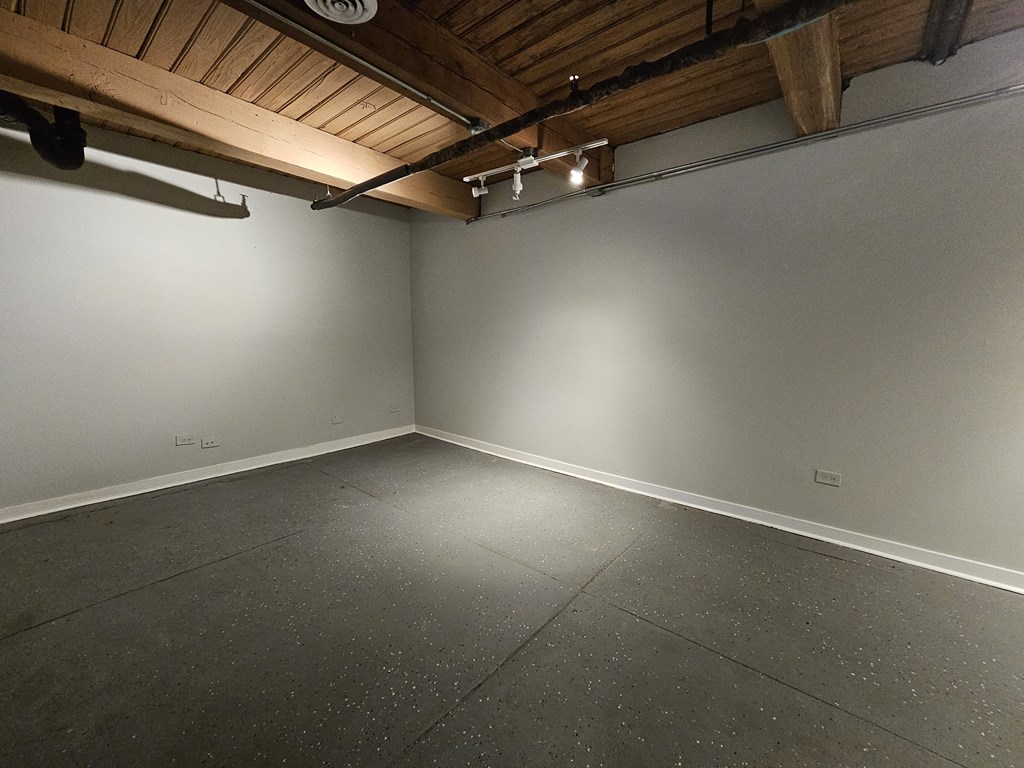 A room with a wooden ceiling and a grey floor.