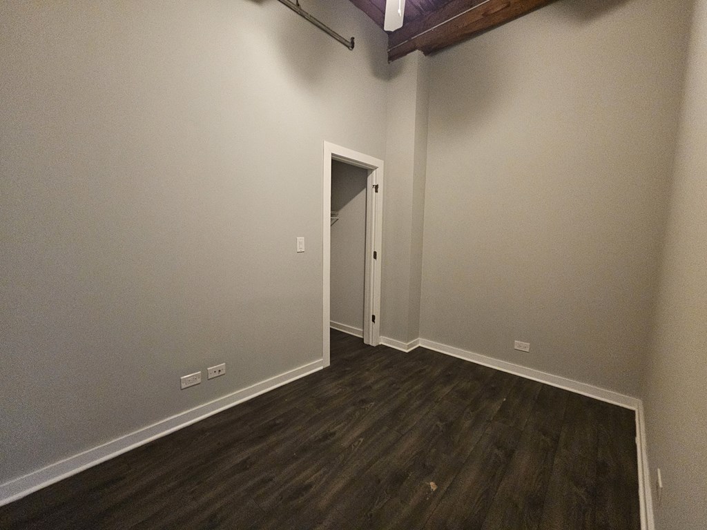 A room with a wooden floor and a white door.