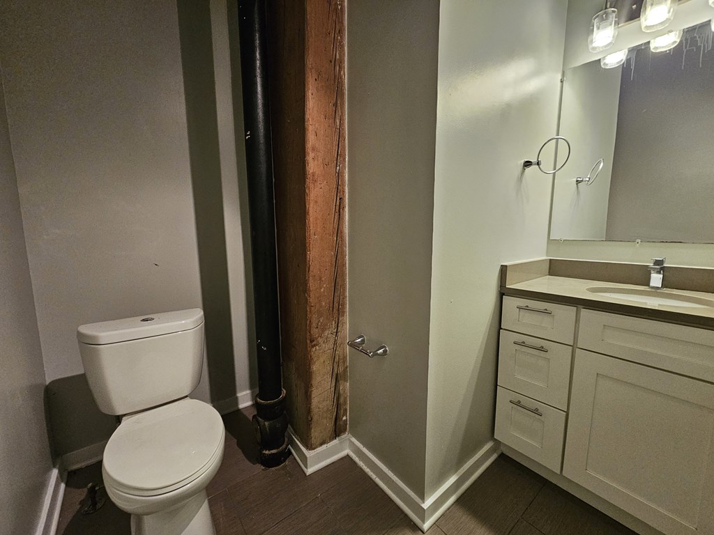 A white toilet sits in a bathroom next to a sink.