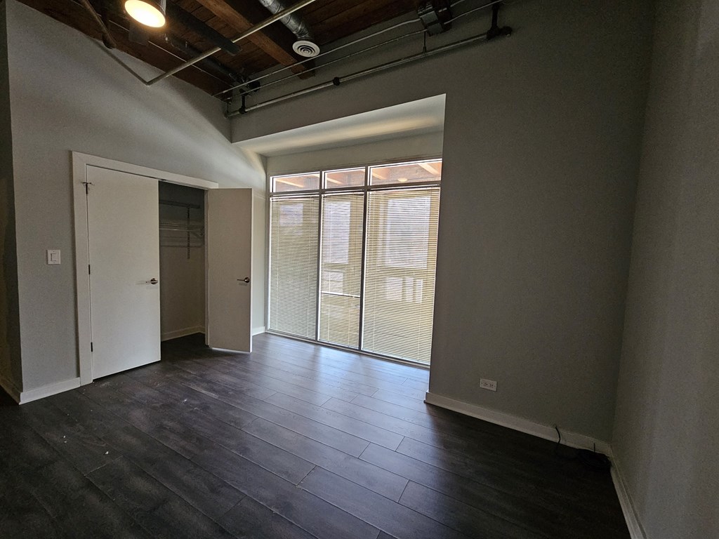 A room with a sliding glass door and a wooden ceiling.