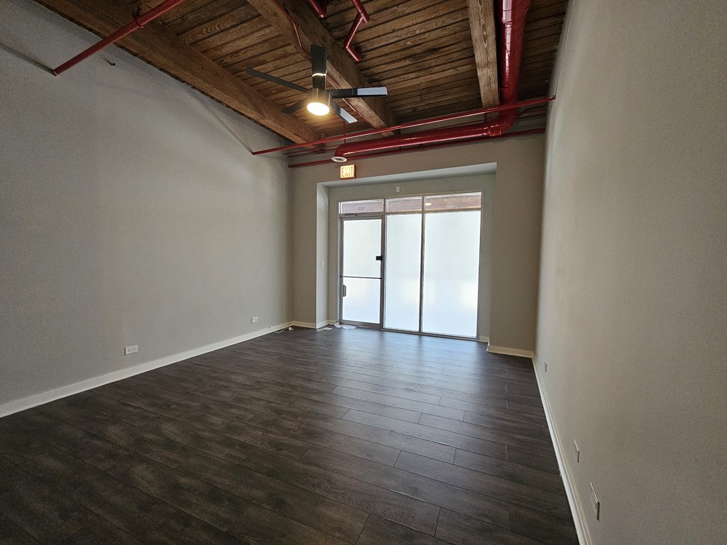 A room with wooden floors and a ceiling fan.
