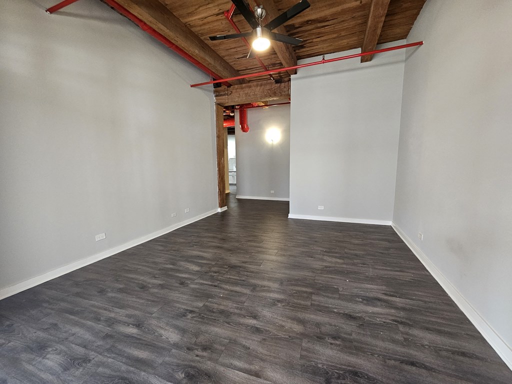 A room with wooden beams and a ceiling fan.