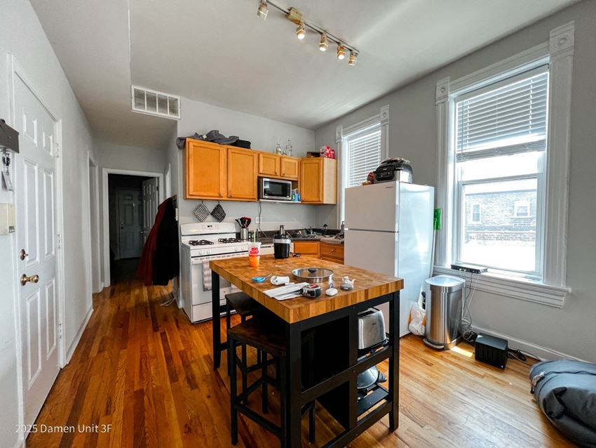 a small kitchen with wood floors and wooden cabinets