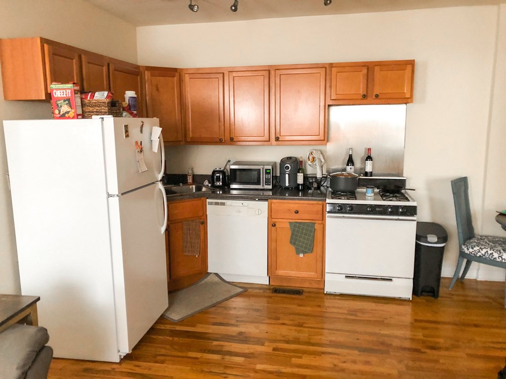a kitchen with white appliances and wooden cabinets