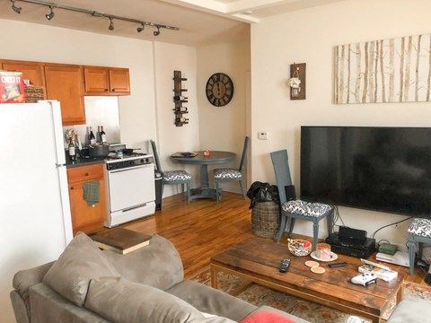 a living room with a couch and a tv and a kitchen