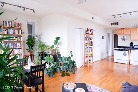 A living room with a dining table, chairs, and a bookshelf.