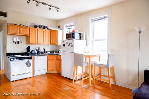 A kitchen with orange cabinets and white appliances.