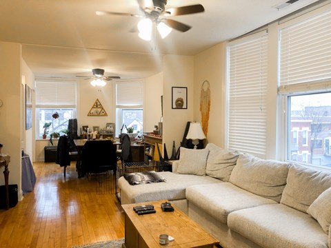 A living room with a white couch and a wooden coffee table.