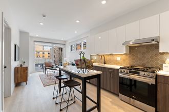 a kitchen with white cabinets and a large island with a breakfast bar