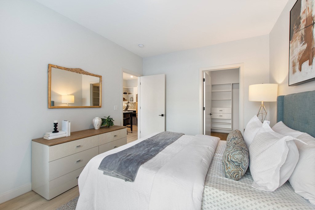 a bedroom with a bed and a dresser with a mirror